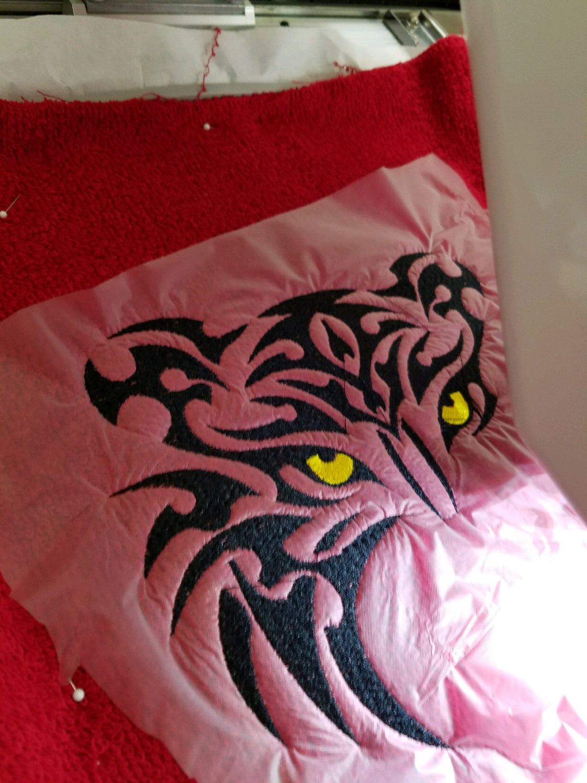 Custom tiger logo embroidery in progress on hooded towel